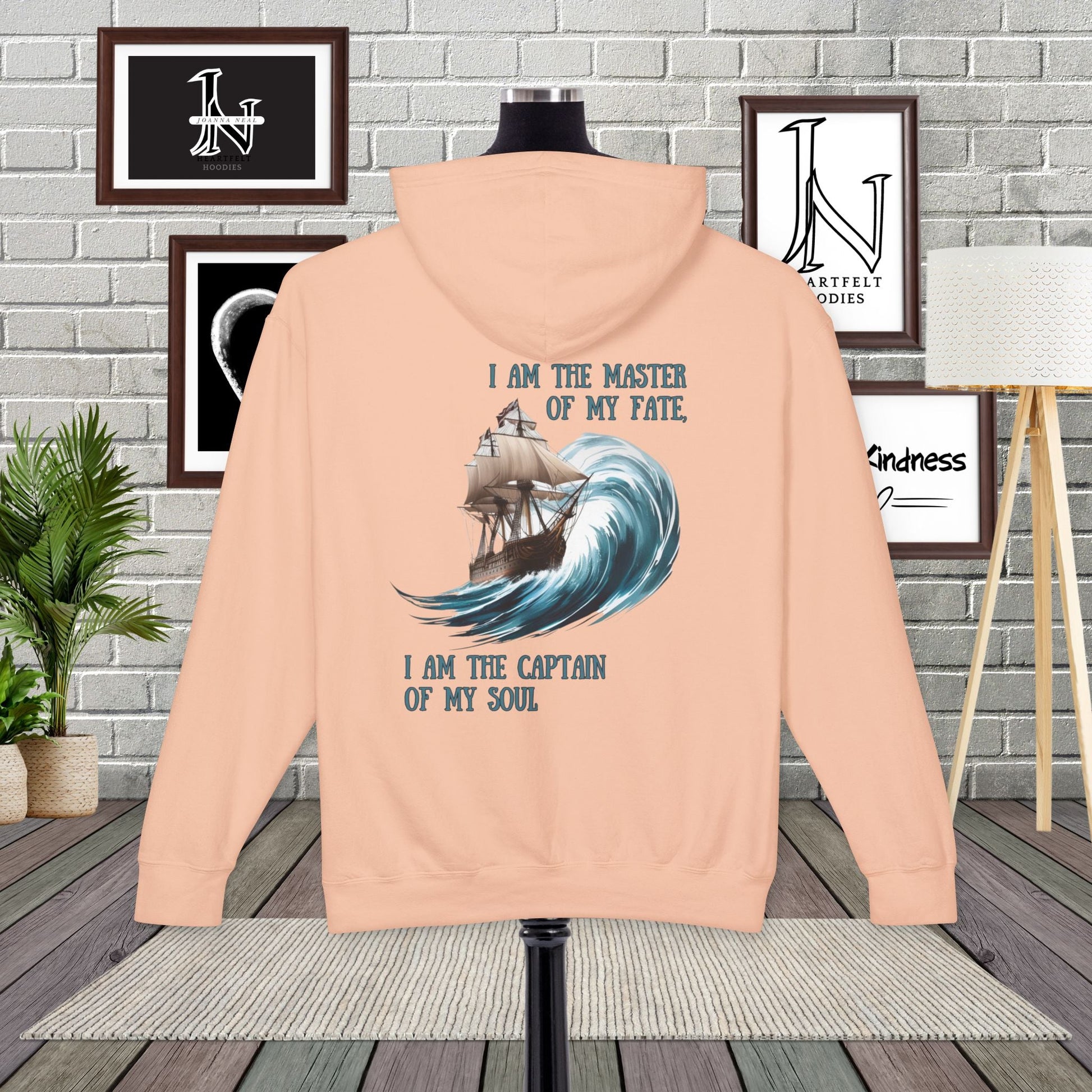 This Piece of Poetry Clothing features a bold and motivational statement: "I am the captain of my soul," paired with a stunning mountain scene under a rising sun.